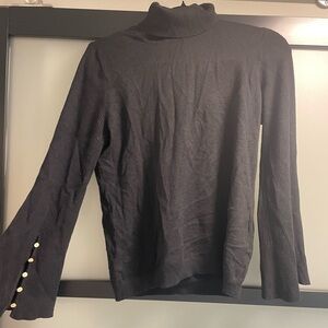 Black turtle neck with gold buttons on the bell bottom sleeves